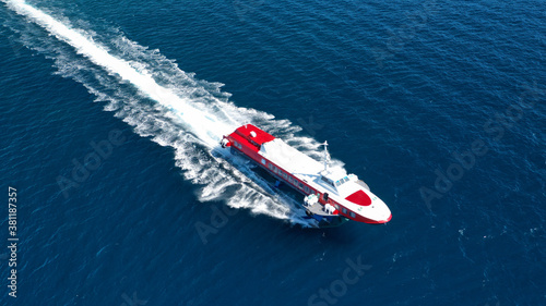 Aerial drone photo of high speed passenger ferry or "flying dolphin" cruising in high speed near port of Piraeus, Attica, Greece © aerial-drone