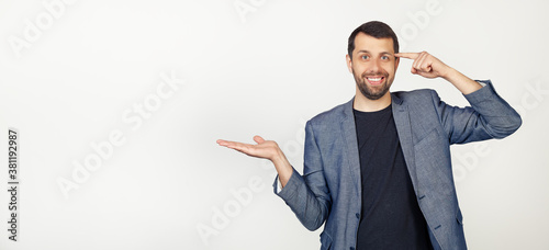 Valokuva Young businessman man with beard smiling and happy with open palm showing copy space and pointing finger to forehead