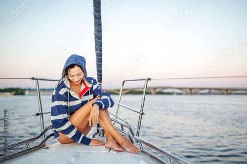 Beautiful girl resting on a yacht at sunset