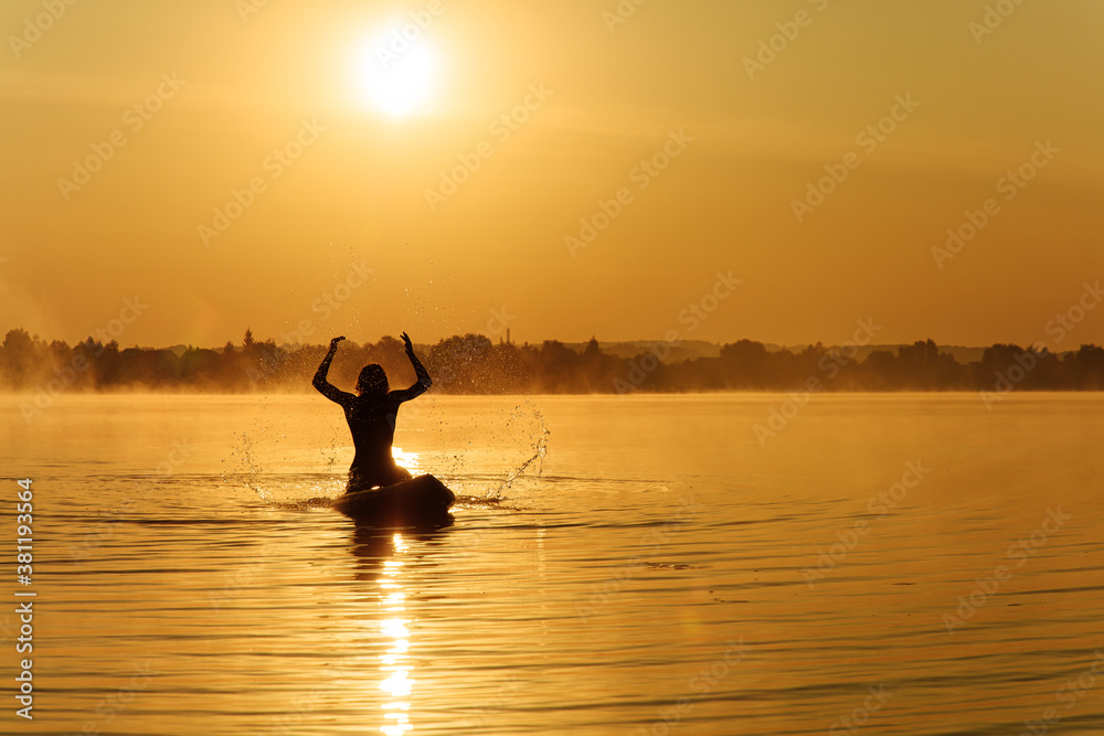 Man making water splashes while floating on sup board