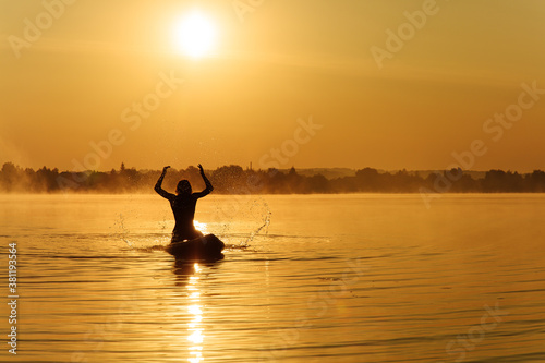 Man making water splashes while floating on sup board © Tymoshchuk