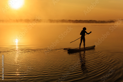 Active man using paddle for swimming on sup board © Tymoshchuk