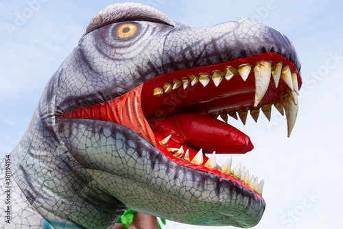 Fototapeta Naklejka Na Ścianę i Meble -  Inflatable dinosaur head on a child's playground against the background of the sky