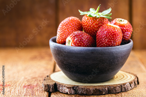 handmade clay pot with strawberries of the Albion variety, with space for text photo