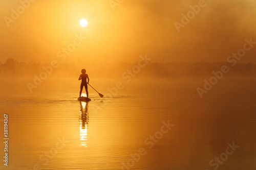 Young man practising in sup boarding during morning time © Tymoshchuk