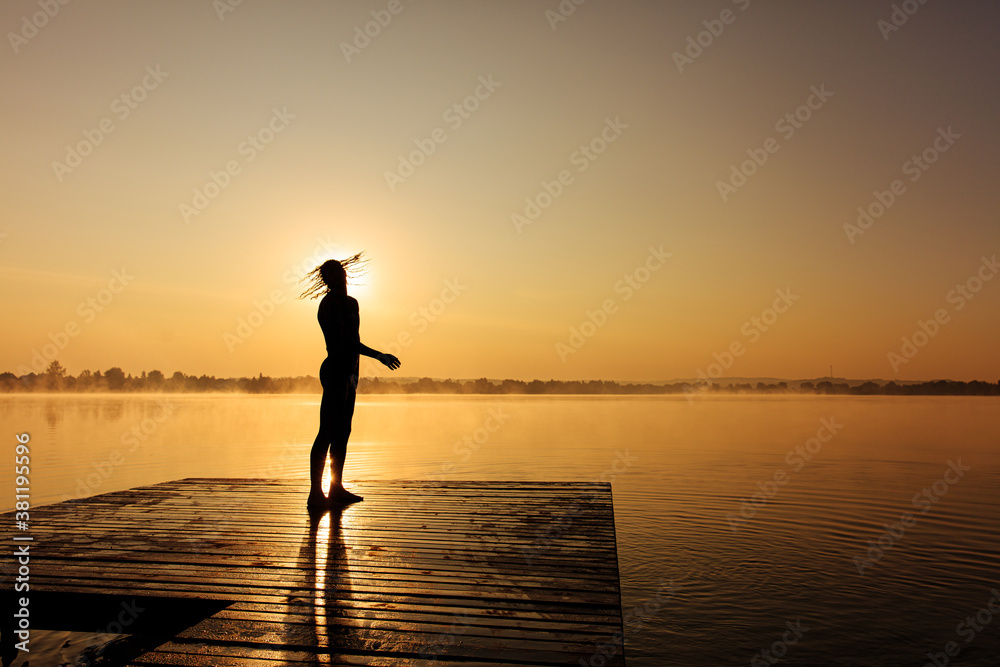 Man standing on pier and shaking with head after swimming