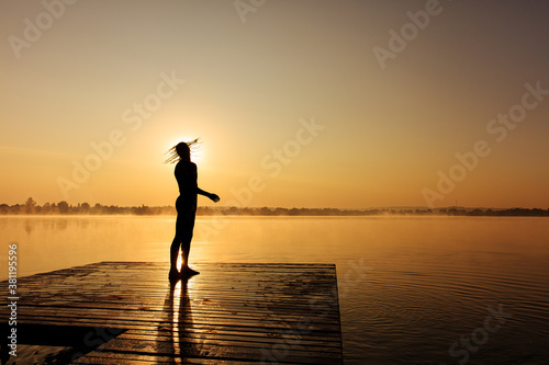 Man standing on pier and shaking with head after swimming