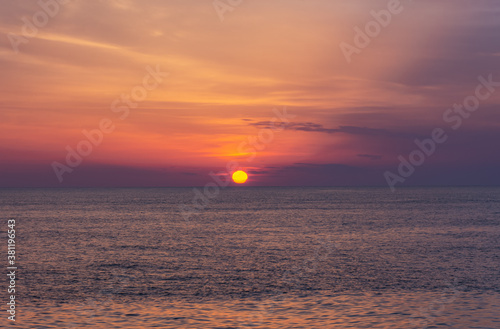Beautiful orange sunset over the sea. The sun sets on the horizon. Relaxing sea landscape. Purple shades of sky and sea water. Sunset over the Black sea. The natural background. © Anna Pismenskova