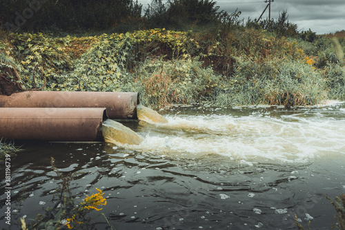 Fotografie sewage pipes pollute the water/sewage pipes pollute the water in the river