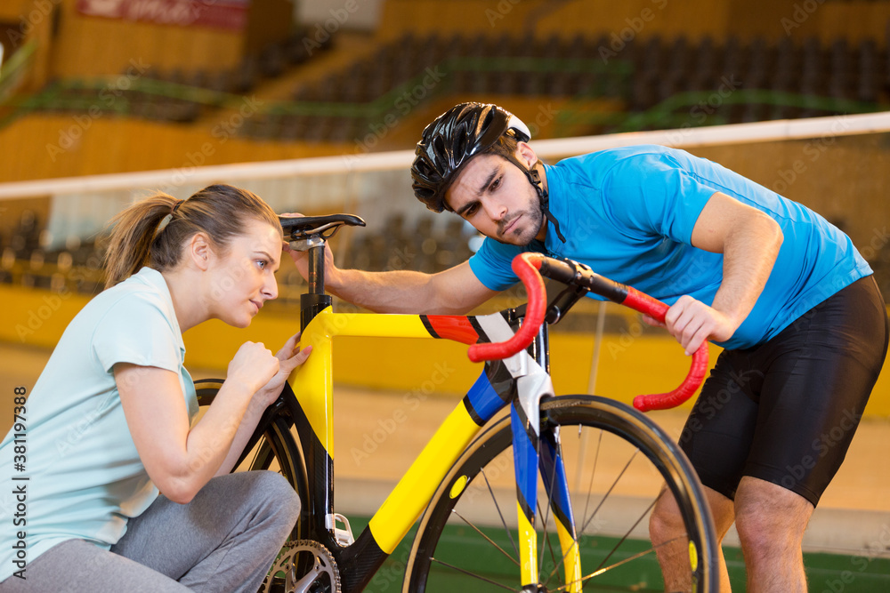 Obraz premium female coach speaking with cyclist on velodrome track