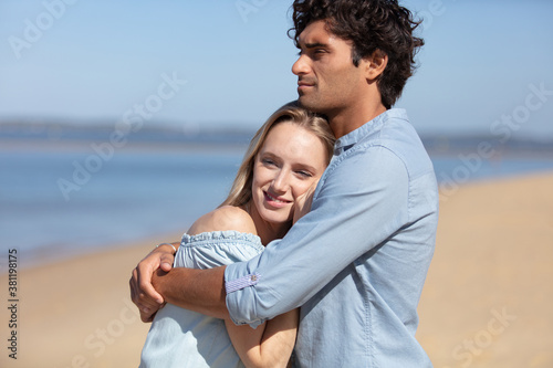 happy young couple hugging on the beach