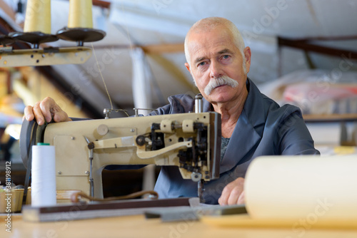 senior mechanic repairing industrial sewing machine