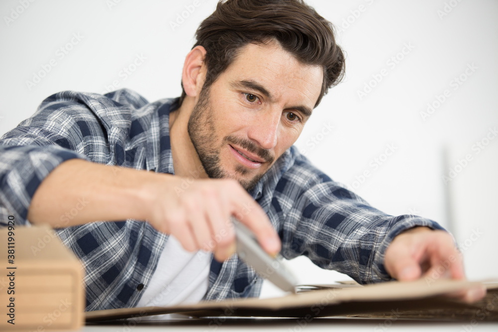 man cuts the cardboard for books man cuts the cardboard for books