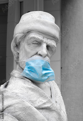 Statue with protective surgery mask, szmbol of SARS-COV 19 protection photo