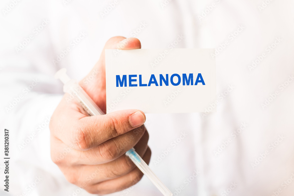 Word melanoma on a white background with a syringe in hand. Medicine concept Word melanoma on a white background with a syringe in hand. Medicine concept
