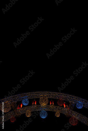 Christmas night street decoration garland illumination lamps on black background outdoor space vertical picture wallpaper patter format with empty copy space for your text