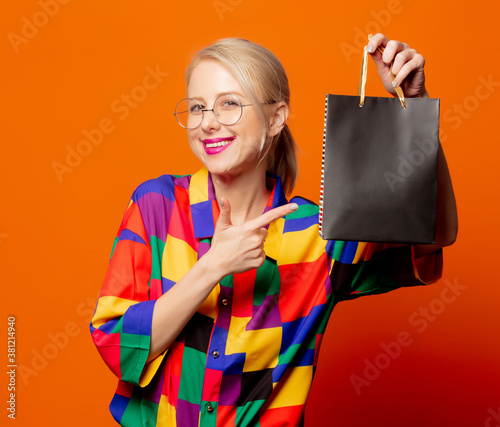 Style blonde in 90s clothes with black shopping bag