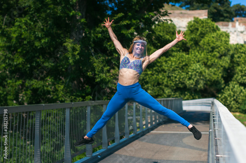 young woman wearing a protective visor and jumping outdoors
