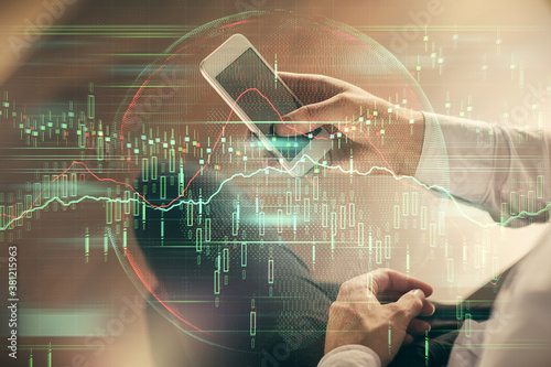 Double exposure of man's hands holding and using a digital device and forex graph drawing. Financial market concept.