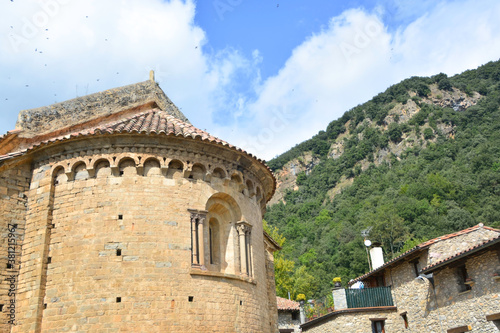 Obraz na płótnie BEGET, CATALONIA, SPAIN, EUROPE, SEPTEMBER 2020. Fantastic Romanesque church of San Cristóbal with a window in the rear vault and surrounded by stone houses in the beautiful medieval town of Beget w salonie