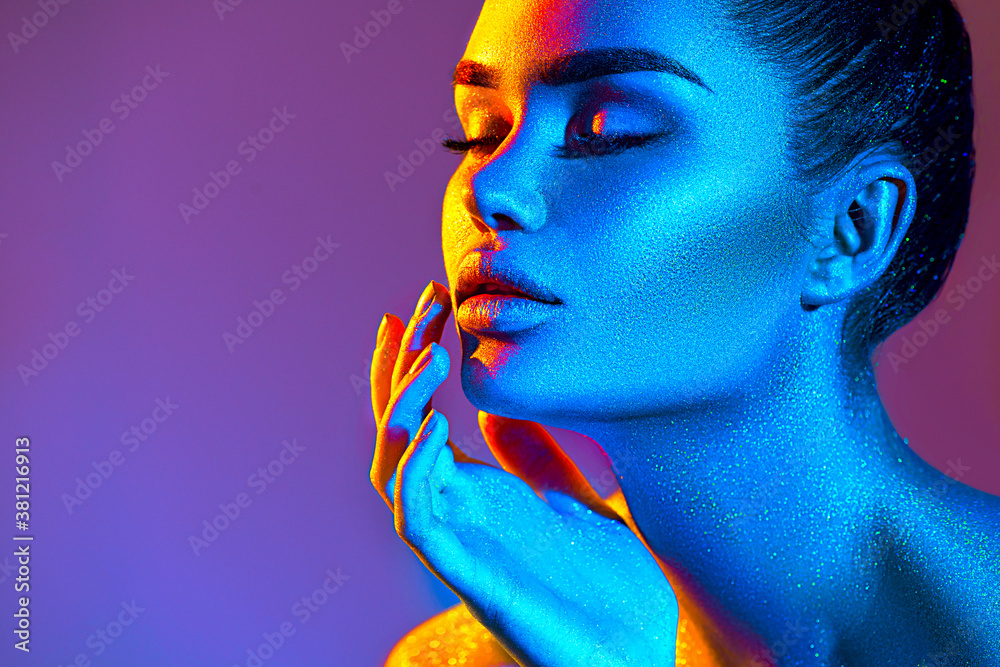 Hæl Tanke Tæl op High Fashion model woman in colorful bright sparkles and neon lights.  Beauty face, portrait of beautiful sexy girl, trendy glowing make-up. Art  design colorful make up. Glitter Vivid neon makeup Stock Photo 