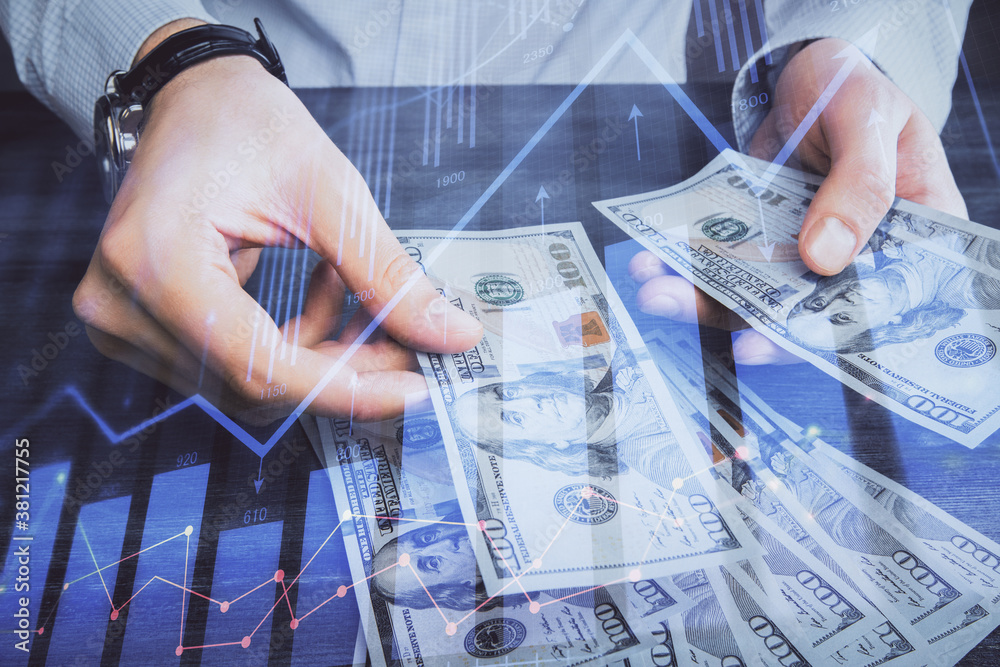 Multi exposure of financial graph drawing hologram and USA dollars bills and man hands. Analysis concept. Multi exposure of financial graph drawing hologram and USA dollars bills and man hands. Analysis concept.
