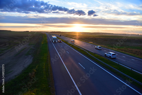 Truck with Semi-trailer driving along highway on the sunset background. Goods Delivery by roads. Services and Transport logistics. Small roughness sharpness, possible granularity
