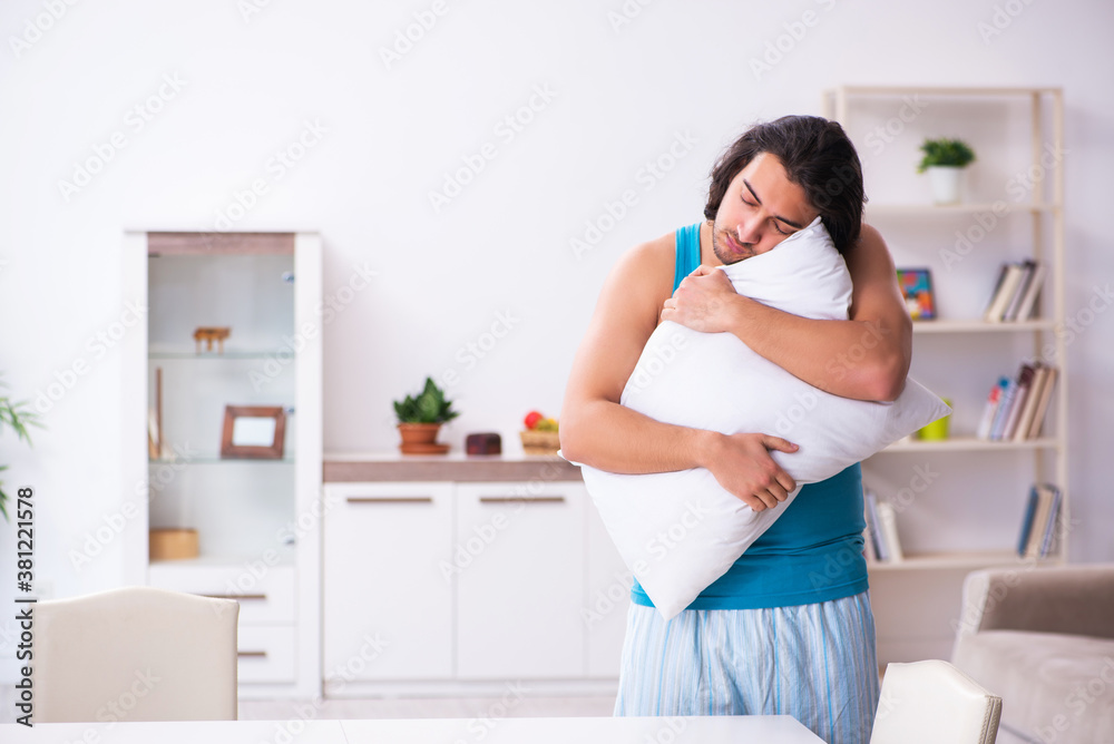 Young man waking up at home