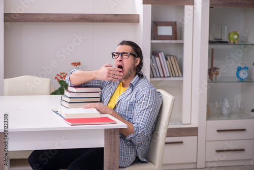 Young male student preparing for exam at home