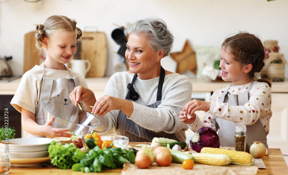 Mature woman with grandchildren preparing healthy food in kitchen Mature woman with grandchildren preparing healthy food in kitchen