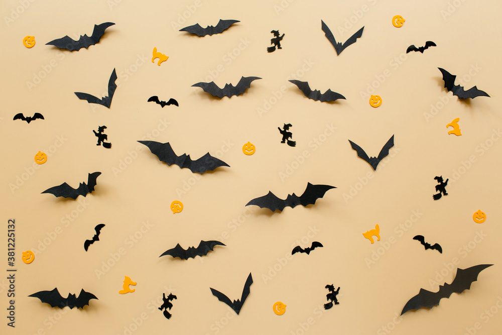 Halloween decorations with pumpkin and bats on pastel beige background. Halloween concept. Flat lay, top view, copy space