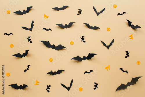 Halloween decorations with pumpkin and bats on pastel beige background. Halloween concept. Flat lay  top view  copy space