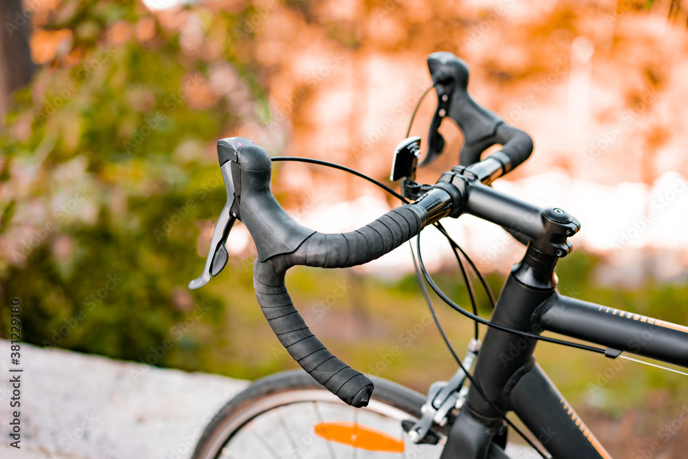 Dropbar handlebar, speed shifter and brakes of road bike on a blurred background of nature. Transport. Transportation. Sport Dropbar handlebar, speed shifter and brakes of road bike on a blurred background of nature. Transport. Transportation. Sport