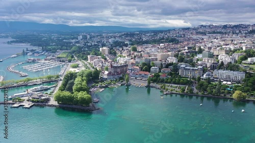 View from drone of lake Leman and houses of swiss city Lausanne in cloudy summer day