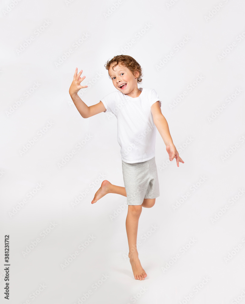 Dancing joyful funny young boy exercising isolated on white background