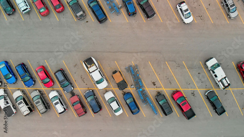 Aerial view of cars at large outdoor parking lots, USA. Outlet mall parking congestion and crowded parking lot, other cars try getting in and out, finding parking space