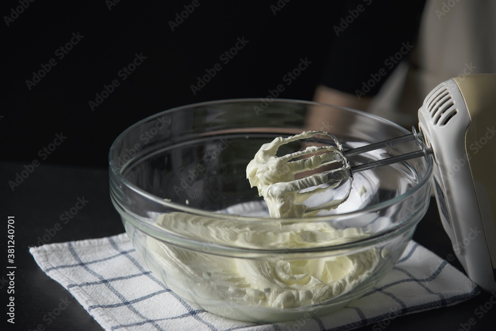 Lady is making cream cake using electric portable mixer machine Lady is making cream cake using electric portable mixer machine