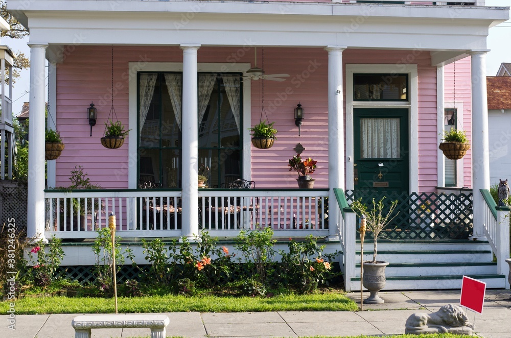 Close up front porch view of Galveston Island pink Victorian house with