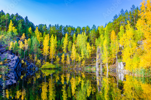Lake among the mountains covered with forest in autumn.