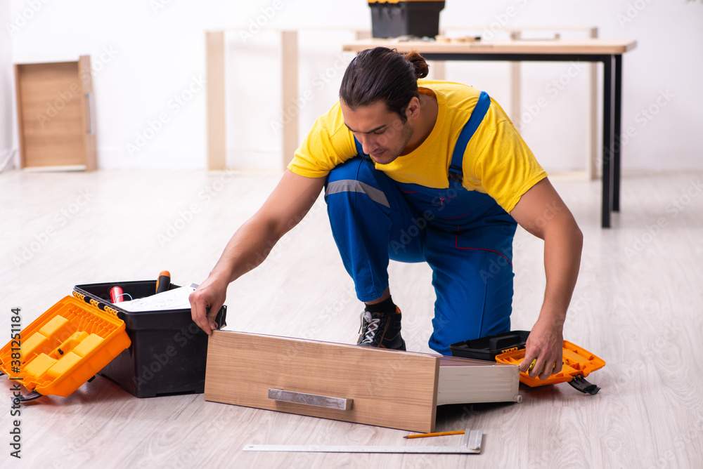 Young male carpenter working indoors Young male carpenter working indoors