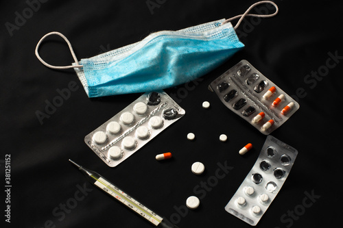 medicines, pills, packaging, mask on a black background photo