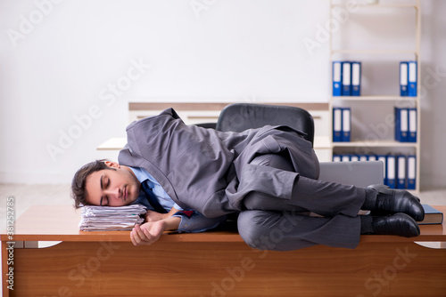 Young male employee sleeping in the office