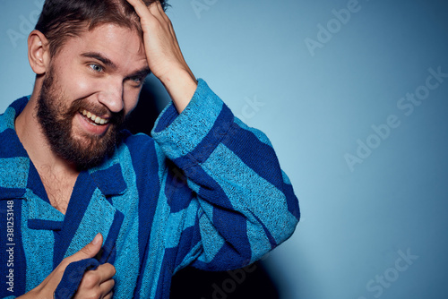 A man in a blue robe on a light background gestures with his hands model home clothes