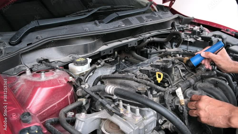 Asian Man mechanic inspection Shine a torch car engine checking bug in engine from application smartphone.Red car for service maintenance insurance with car engine.for transport automobile automotive Asian Man mechanic inspection Shine a torch car engine checking bug in engine from application smartphone.Red car for service maintenance insurance with car engine.for transport automobile automotive