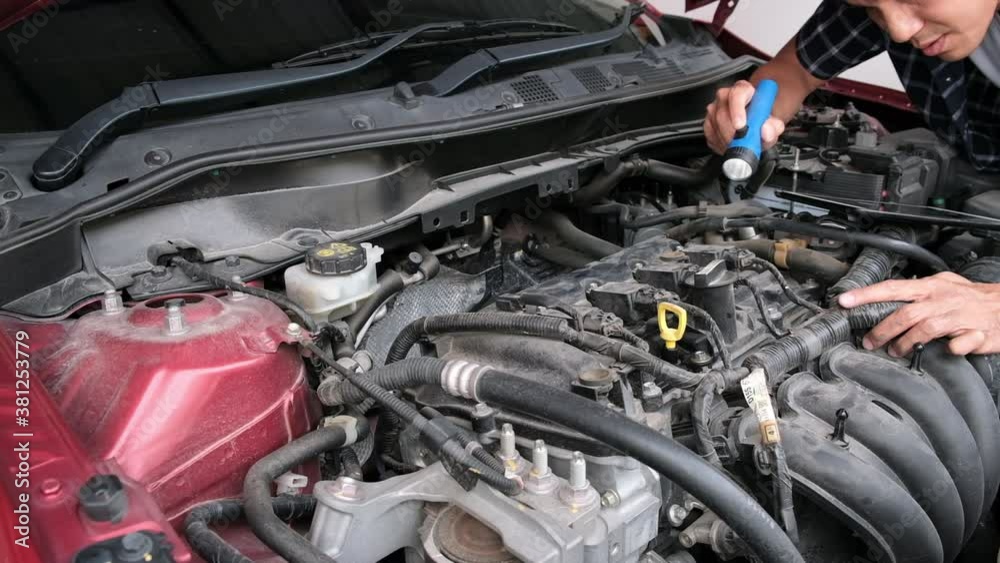 Asian Man mechanic inspection Shine a torch car engine checking bug in engine from application smartphone.Red car for service maintenance insurance with car engine.for transport automobile automotive Asian Man mechanic inspection Shine a torch car engine checking bug in engine from application smartphone.Red car for service maintenance insurance with car engine.for transport automobile automotive