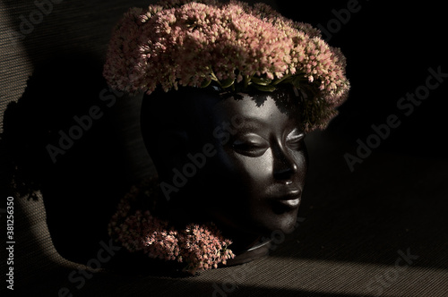 vase in the shape of a girl's head with flowers close-up