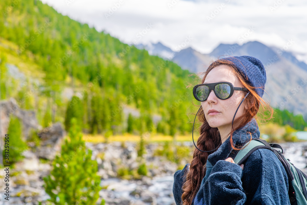 Young woman with backpack enjoys the view of enjoys the view of the Multinsky lake. Empty space for text Young woman with backpack enjoys the view of enjoys the view of the Multinsky lake. Empty space for text