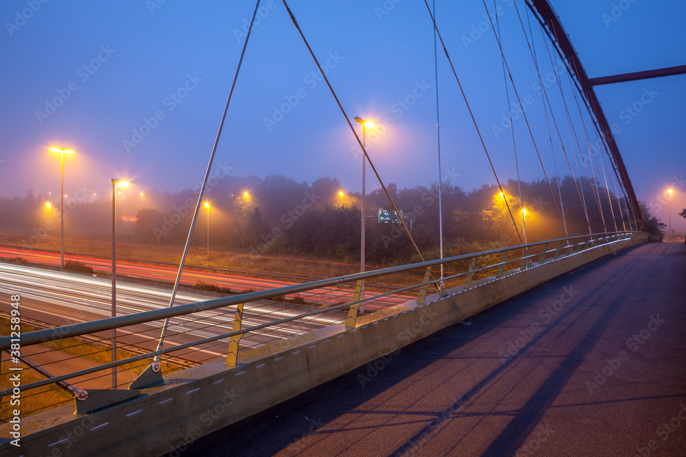 Bridge over freeway in the early morning with fog