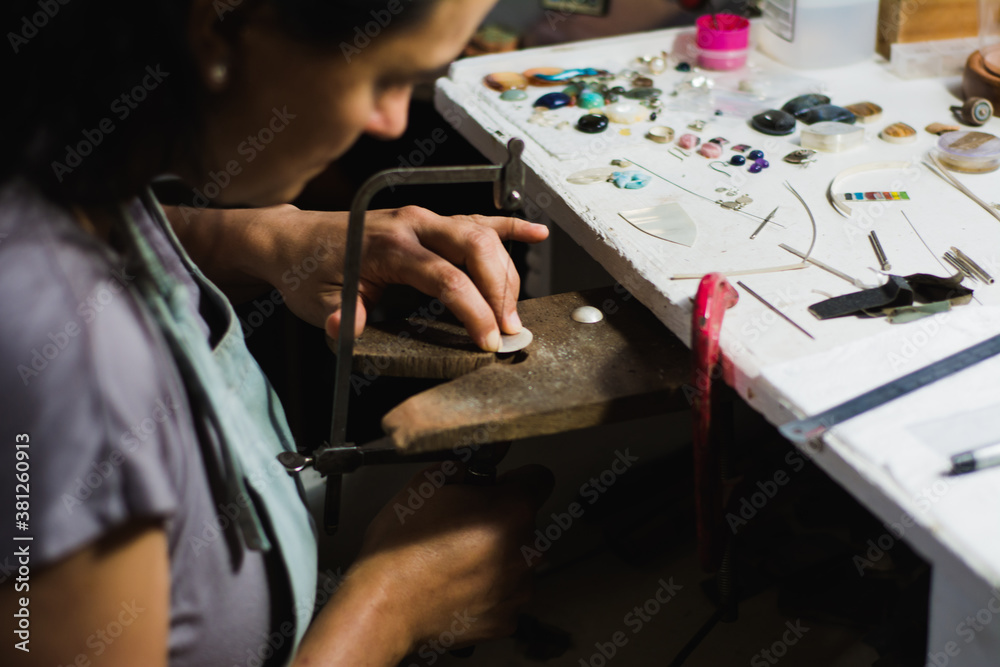 Jewelry maker cutting metal with a band saw in the workshop. Professional jewelry jeweler on your workbench. Jewelry maker cutting metal with a band saw in the workshop. Professional jewelry jeweler on your workbench.