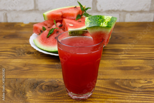 Glass of fresh watermelon juice on a wooden table